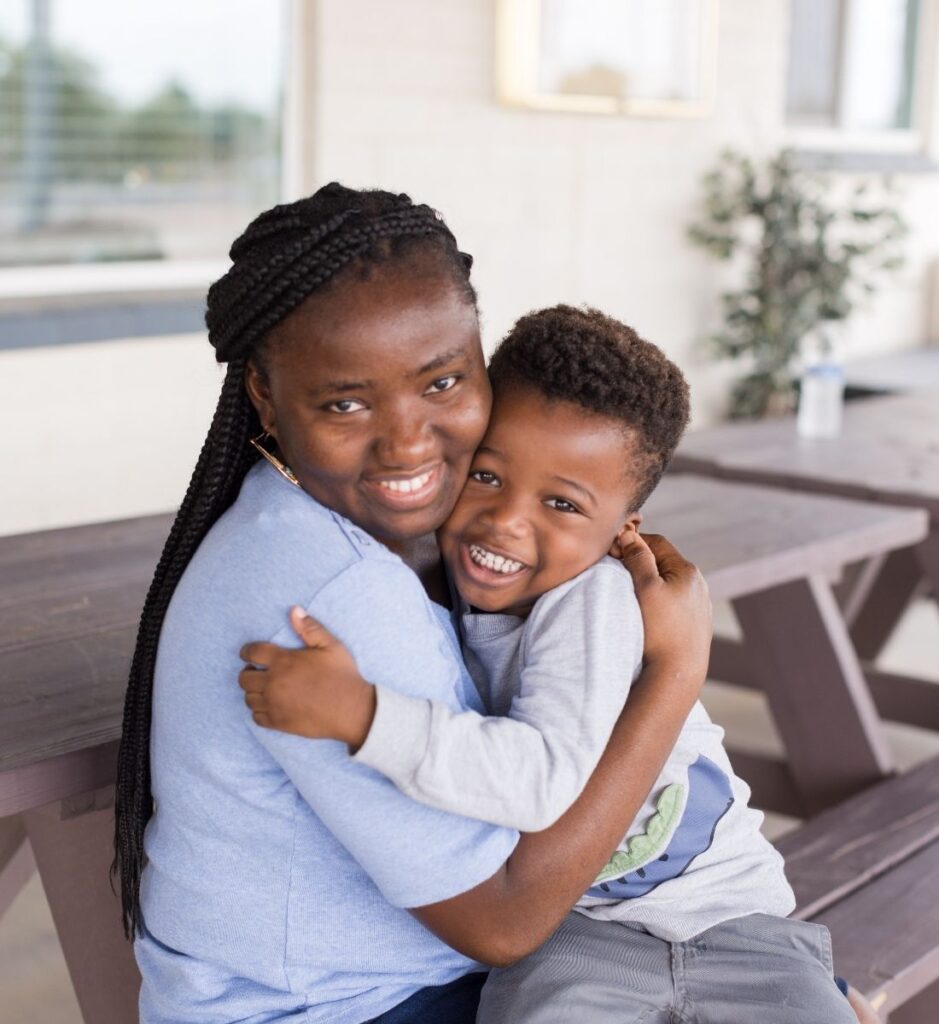 Mother and son hugging while sitting and smiling